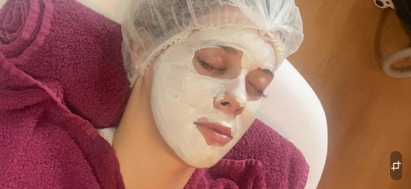 Gesichtsbehandlung im Studio: Kundin entspannt mit aufgetragener Crememaske